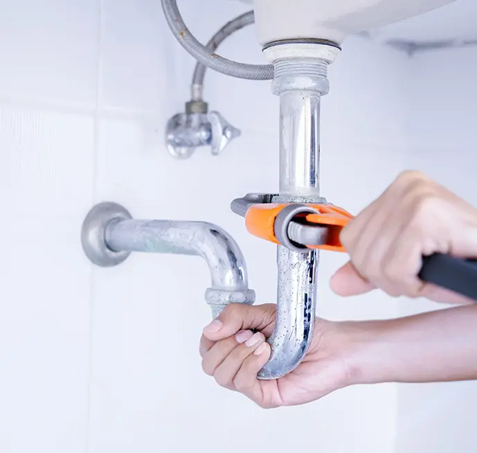 A plumber working on a sink drain