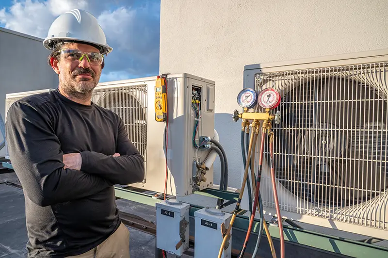 HVAC technician servicing an outdoor AC unit.